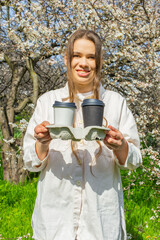 Young woman holding a takeaway coffee cups