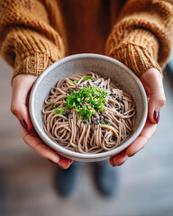 warm bowl of noodles in hands, comfort food vibe