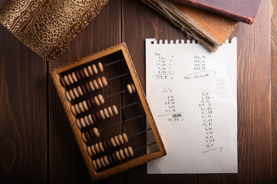 Vintage wooden abacus with accounting sheet on desk for financial history, math education or business