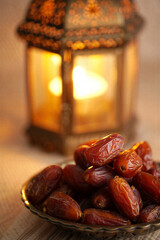 Glossy Dates on Wooden Plate with Glowing Lantern Background, Ramadan Kareem Iftar, Jumma Mubarak Blessings, Traditional Fast-Breaking Meal