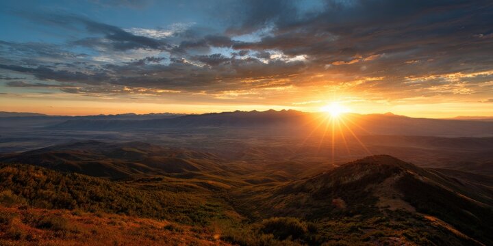 Majestic mountain sunset with vibrant sky and sunbeams over rolling hills