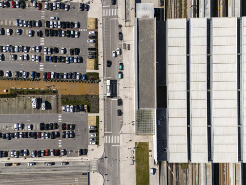 Aerial view of the city's organized parking lot juxtaposed against the architectural symmetry of the station, a dance of urban planning and transit, Aveiro, Portugal.