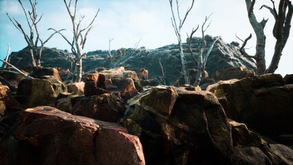 Obraz premium Barren landscape featuring rugged rocks and dry branches reaching toward a blue sky. The scene captures a sense of solitude and natural beauty during daylight.
