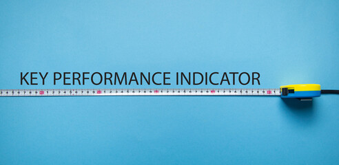 Tape measure with a text Key Performance Indicator on the blue background.