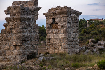 Ancient Roman aqueduct ruins in Manavgat. Massive stone pillars of an antique water supply system against a cloudy sky. Historical heritage site in the Mediterranean region, Antalya, Turkey. September