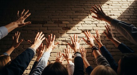 Raised hands against brick wall background