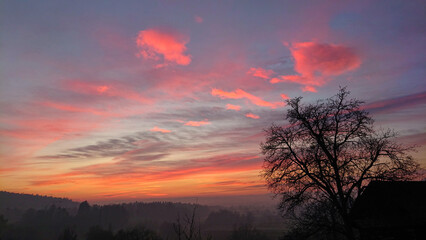 Beautiful early morning autumn sky illuminates the picturesque rural landscape.