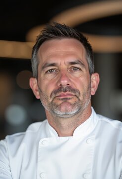 Selbstbewusster Koch in moderner Restaurantk&uuml;che Portrait eines erfahrenen Chefkochs