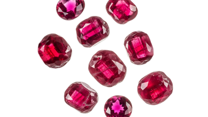 A group of red ruby gemstones scattered on a white background, showcasing their vibrant color and intricate facets.