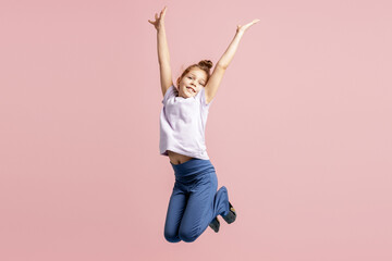 Happy child jumping with arms raised, celebrating joy and carefree childhood