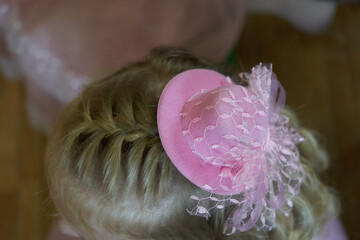 little girl with a French braid combed from above, Children's hairstyle, french braid and mini hat. Top view