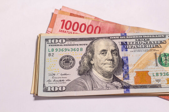US dollars banknotes top of rupiah banknotes