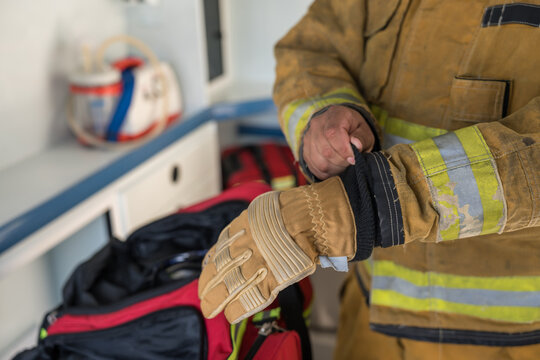 Firefighter putting on protective glove in emergency situation