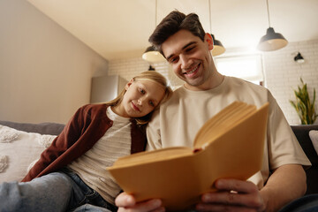 Father and daughter bonding with their golden retriever at home