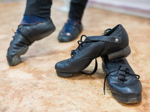 A man dancing Irish dances. Professional shoes are in the foreground.
