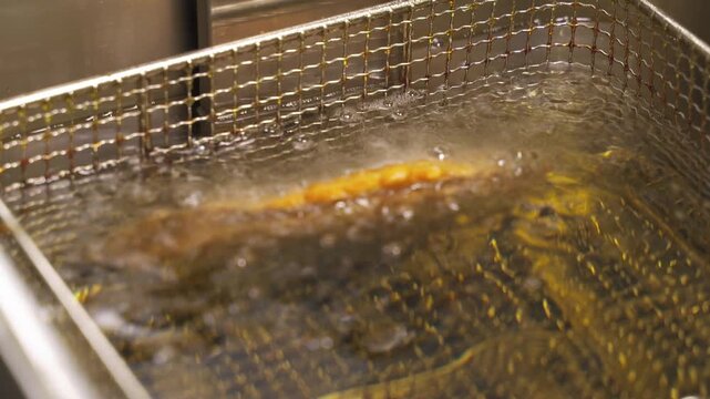 Watch the satisfying process of frying chebureki in rich vegetable oil. The dough transforms into a crispy treat, bubbling and golden, a delightful snack fresh from the pan.