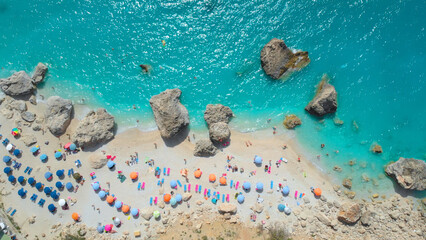 AERIAL: People having fun on the scenic sandy beach of isle in the Mediterranean