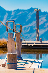 Alpine summer view with details of rope eyelets and reflections in a pond at Mount Resterkogel, Mittersill, Oberpinzgau, Salzburg, Austria