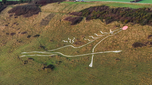 Aerial view of the Folkestone White Horse gleaming against the muted green hillside, a striking contrast of ancient art and natural beauty, Folkestone, England, United Kingdom.