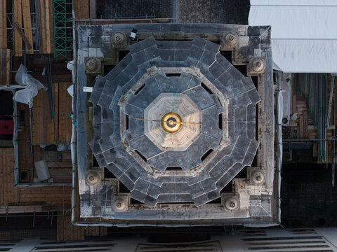 Aerial view of the octagonal dome shimmering with a golden orb, a beacon amidst the intricate stonework and scaffolding surrounding it, London, United Kingdom.