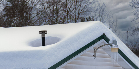 After a very heavy snow fell on Upstate NY, this roof is completely buried except where the chimney...
