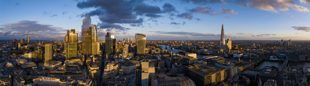 Aerial view of the River Thames snaking through the city, with iconic buildings like The Shard and the Walkie Talkie gleaming in the sunlight, London, England, United Kingdom.