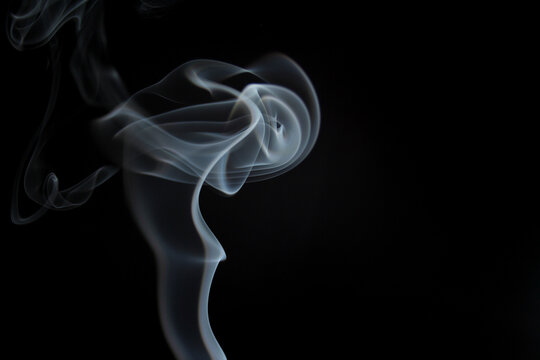 voluta de humo blanco flotando sobre un fondo color negro