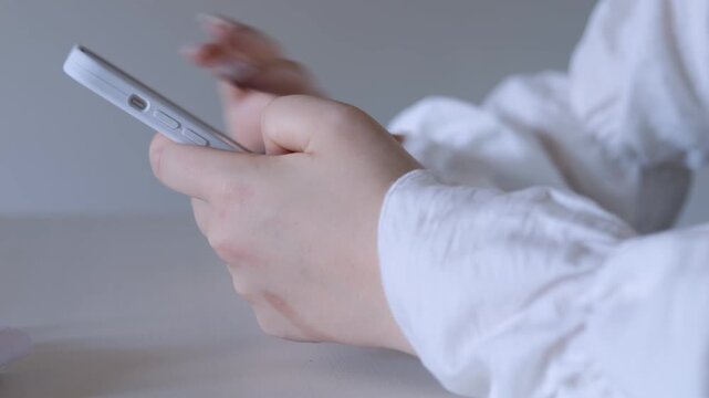 Person is holding a cell phone in their hand. The phone is white and has a pink case