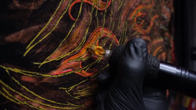 tattoo machine painting the year of fire with acrylic paints on fabric