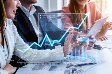 A business team actively discussing financial strategies using digital data visualization. The modern office setting enhances collaboration and communication. Scalp