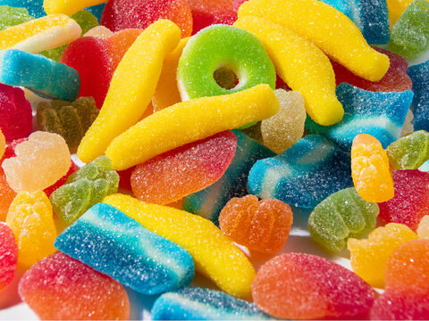 fotografia macro de un pu&ntilde;ado de caramelos de goma de distintas formas y colores