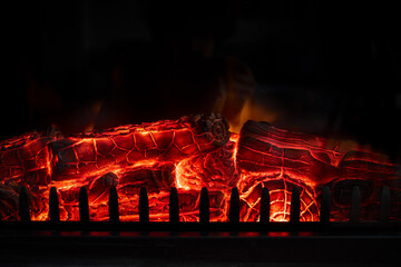 Glowing firewood burning in a fireplace with red hot embers