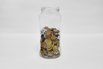 Creative Savings Concept: Coins and Metal Hardware in Glass Jar on Minimal White Background
