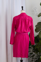 Pink belted dress in 1980s style on a mannequin