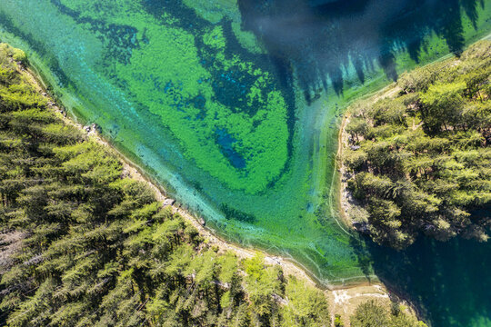 Aerial view of the Gruner See's crystal-clear turquoise waters meet the lush green forests, creating a stunning contrast of color and texture, Green Lake - Gruner See, Styria, Austria.