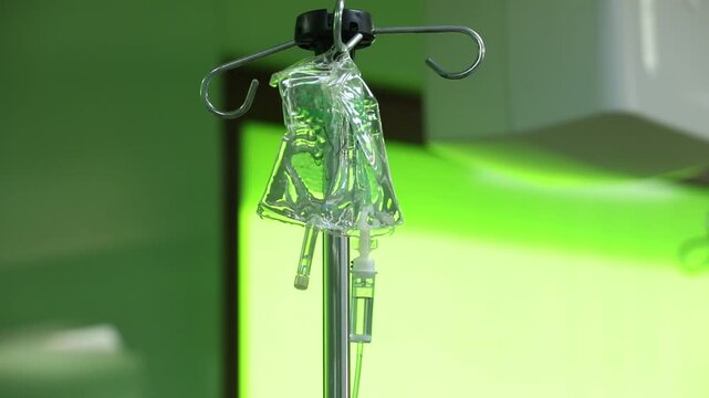 Close-up of medical intravenous infusion drip. Saline solution bag hanging on a pole in a hospital ward. Liquid medicine dripping in the chamber for patient treatment.

