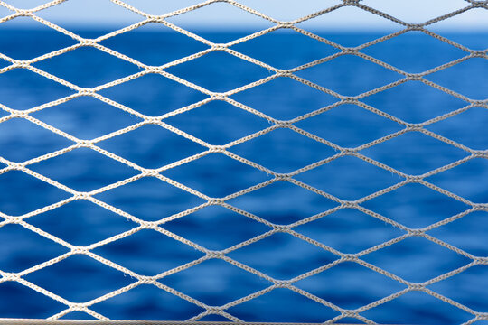 Gros plan sur un filet de protection de bateau avec du soleil qui l'&eacute;claire et de l'ombre.