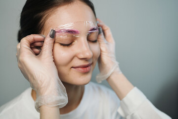 Young woman smiling with protective brow film after treatment