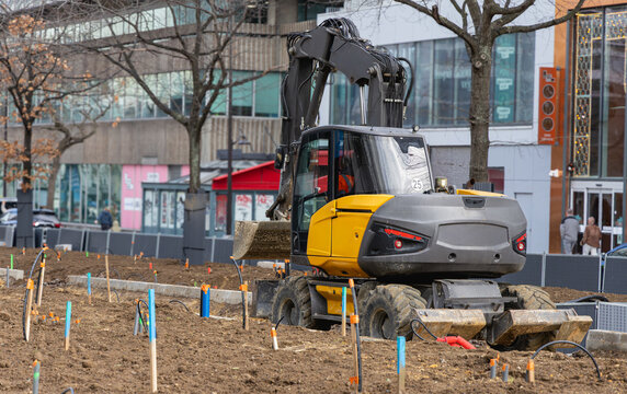 Gros plan sur un tractopelle en train d'effectuer des travaux dans la rue.