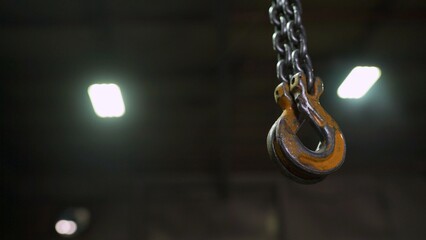 Heavy industrial crane hook hanging in workshop