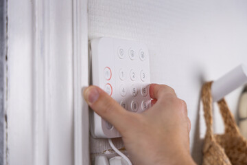 Vue rapproch&eacute;e d&rsquo;une personne posant une alarme domestique.