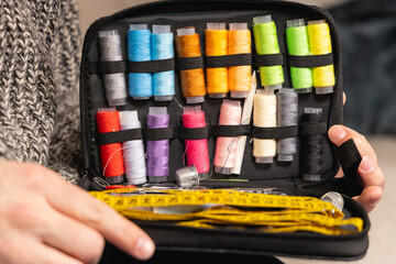 Gros plan sur une trousse à couture ouverte avec des bobines de fil, un mètre ruban et tout le matériel nécéssaire. © Gautier Normand