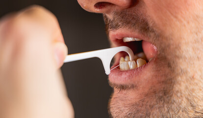 Une personne prenant soin de ses dents en utilisant du fil dentaire. © Gautier Normand