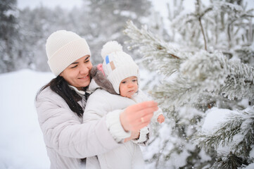 Mother and baby enjoying winter wonderland snow