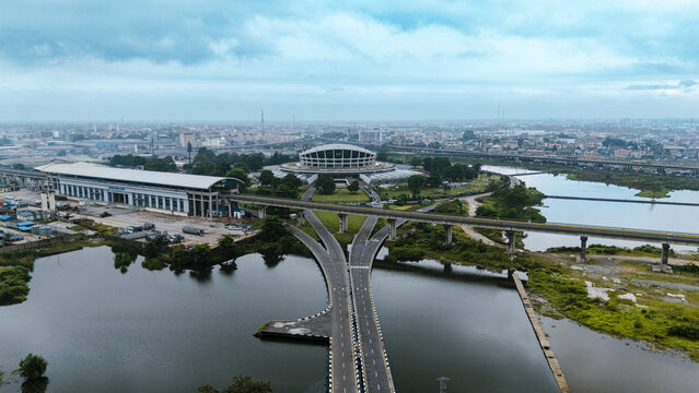 Aerial view of the National Theatre and a modern interchange bridge over rippling waters under a vast sky, Lagos, Lagos, Nigeria.