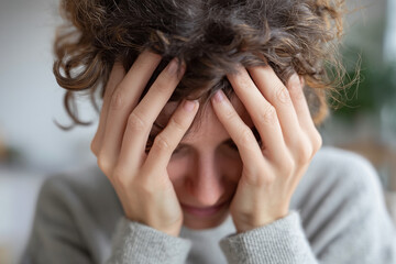 Fototapeta premium A woman with her hands on her head, looking sad