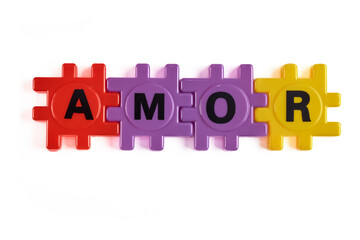 The word "love" in Spanish with vibrant plastic blocks in a gradient.