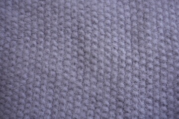 Delicate purple knitted wool texture background  texture of delicate purple knitted wool fabric. Soft cozy textile background with detailed knit pattern and gentle lavender tones.