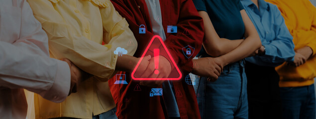 A group of diverse individuals stands together in front of a glowing warning sign symbolizing digital security and privacy issues, highlighting modern challenges in technology. Trope