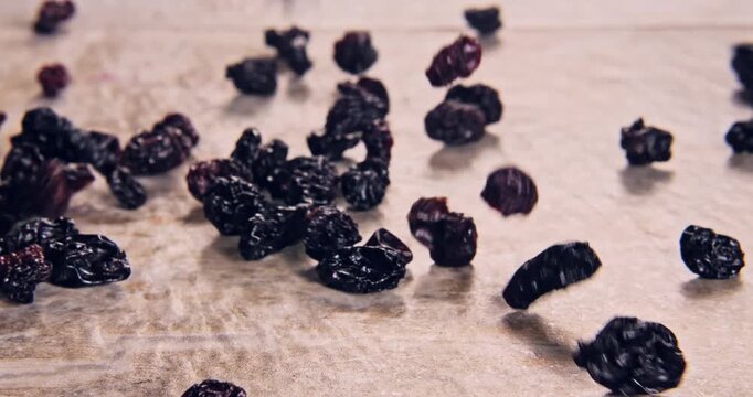 Front view of low speed falling raisins on a natural surface.